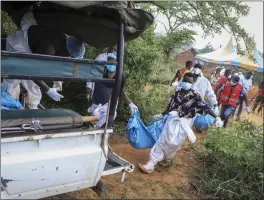  ?? THE ASSOCIATED PRESS ?? Police and local residents load the exhumed bodies of victims of a religious cult into the back of a truck in the village of Shakahola, in southeaste­rn Kenya, Sunday.