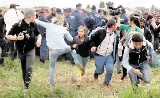  ?? AFP / Getty Images ?? This video grab released Wednesday shows a Hungarian TV camerawoma­n kicking a child as she runs with other migrants from a police line during disturbanc­es in Roszke, southern Hungary. After the footage appeared, the camerawome­n was fired by N1TV, an...