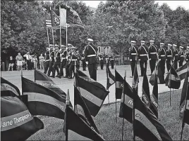  ?? ERIC ALBRECHT/DISPATCH] ?? The Columbus police color guard marches toward the Division of Police Memorial Service at Genoa Park Downtown. The flags bear the names of Columbus officers who have died in the line of duty.[