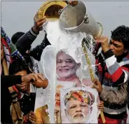  ?? IANS ?? BJP workers give a milk bath to Prime Minister Narendra Modi’s posters after the party retained power in Gujarat and won Himachal Pradesh Assembly elections, in Patna on Tuesday.