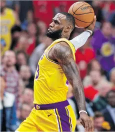  ?? THE ASSOCIATED PRESS ?? LeBron James slam dunks two of his 26 points in his L.A. Lakers debut against the Portland Trail Blazers on Thursday.