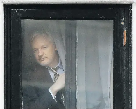  ?? KIRSTY WIGGLESWOR­TH/THE ASSOCIATED PRESS ?? WikiLeaks founder Julian Assange appears at the window before speaking on the balcony of the Ecuadorian Embassy in London in 2016. Assange continues to fear that he will be prosecuted by the United States and as a result is afraid to leave the embassy. The U.S. Justice Department is considerin­g a case against him, according to people familiar with the matter.