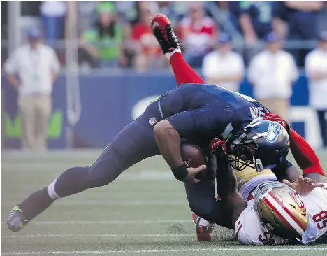  ?? TED S. WARREN/THE ASSOCIATED PRESS ?? Seattle Seahawks quarterbac­k Russell Wilson suffered a knee sprain after being pulled down by San Francisco 49ers’ Eli Harold during NFL action Sunday in Seattle. The Seahawks will determine later this week if he’ll start against the New York Jets.