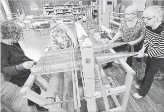  ?? MATHEW MCCARTHY WATERLOO REGION RECORD ?? Judy Ginsler, left, Susan Neff, Helene Bindsei and Barb Dares feed yarn through a loom at the Kitchener-Waterloo Weavers’ and Spinners’ Guild.