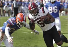  ?? JOHN RAOUX - THE ASSOCIATED PRESS ?? South Carolina running back Rico Dowdle (5) runs past Florida defensive back Jeawon Taylor (29) for a 4-yard touchdown in the second half of an NCAA college football game, Saturday, Nov. 10, 2018, in Gainesvill­e, Fla.