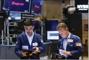  ?? DAVID L. NEMEC — NEW YORK STOCK EXCHANGE ?? Traders Orel Partush, left, and Robert Charmak work on the floor of the New York Stock Exchange on Friday.