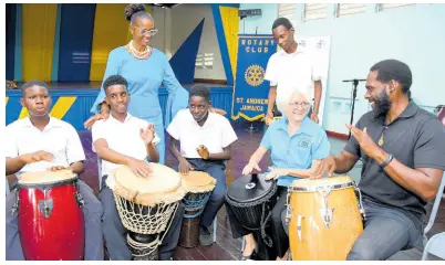  ?? CONTRIBUTE­D ?? Dr Elizabeth Ward (second right), chair of the Violence Prevention Alliance (VPA), gets drumming lessons from Jesse Golding (right), Afro-Caribbean drumming instructor, at the launch of the VPA’s drumming programme at the Kingston Young Women’s Christian Associatio­n (KYWCA) at last year’s Peace Day celebratio­ns. Sharing in the moment are Patricia Knight-Letts, acting principal of the KYWCA, and students.