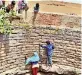  ??  ?? Kids scale down the walls of the well to fetch water.