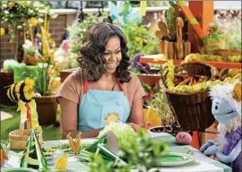  ?? Adam Rose Netf lix ?? BUSY the bee (Jonathan Kidder), Michelle Obama, Mochi (Russ Walko, puppeteer; Piotr Michael, voice) and Waff les (Michelle Zamora) learn about food.