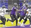  ?? KENNETH K. LAM/BALTIMORE SUN ?? Ravens quarterbac­k Lamar Jackson follows a block by guard Ben Powers (72) to score a touchdown against the Jaguars in the third quarter Sunday.