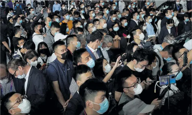  ?? AP / NG HAN GUAN ?? Los asistentes a la feria del automóvil Auto China 2020, protegidos con mascarilla­s en Pekín.