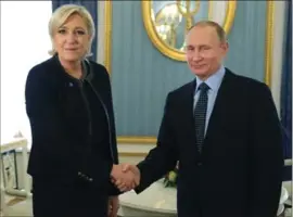  ?? MIKHAIL KLIMENTYEV, THE ASSOCIATED PRESS ?? Russian President Vladimir Putin shakes hands with French far-right presidenti­al candidate Marine Le Pen, in the Kremlin in Moscow on Friday.