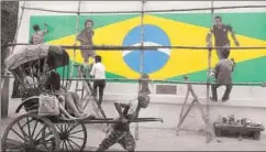  ?? SAMIR JANA/HT PHOTO ?? A handricksh­aw puller moves past a wall painted with graffiti of Brazilian football players ahead of the World Cup that begins in Russia on Thursday