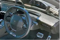  ??  ?? The idiosyncra­tic iCockpit puts the steering wheel down low. The carbon-look finish runs across the dashboard.