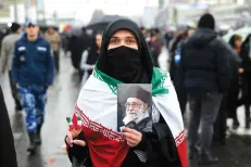  ?? Ebrahim Noroozi)/Associated Press ?? ■ An Iranian woman holds up a portrait of Iranian Supreme Leader Ayatollah Ali Khamenei on Monday as she makes the victory sign during a rally marking the 40th anniversar­y of the 1979 Islamic Revolution in Tehran, Iran.