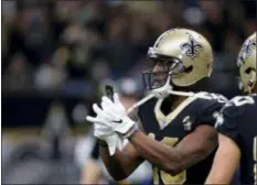  ?? BILL FEIG — THE ASSOCIATED PRESS ?? Saints receiver Michael Thomas pulls out a cell phone to celebrate his 72-yard touchdown catch against the Rams in New Orleans Sunday.