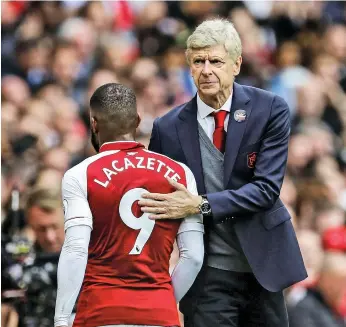  ?? Reuters ?? Arsene Wenger congratula­tes Alexandre Lacazette, who was denied a fifth goal since his transfer by a sturdy post. Goals from Nacho Monreal and Alex Iwobi were enough to defeat Brighton