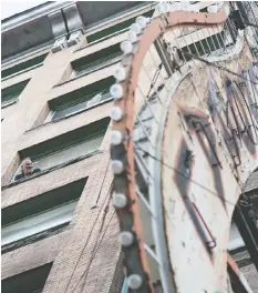  ?? JASON PAYNE/ PNG FILES ?? A man peers out from the Balmoral hotel back in 2017. The owner has launched a legal challenge to the city’s plan to expropriat­e the building.