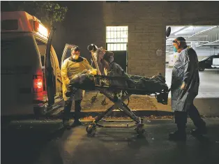  ?? NEW YORK TIMES FILE PHOTO ?? Joshua Berrios, left, helps his partner, Alexander Stevens, transfer a COVID-19 patient to a nursing home last month in Hollywood, Calif.