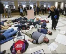  ?? MARK WALLHEISER — THE ASSOCIATED PRESS ?? Florida Rep. Janet Cruz (D-Tampa) walks around a group of 20 college students and activists as they stage a die-in on the 4th floor rotunda between the House and Senate chambers while the House takes up the school safety bill at the Florida Capital in...