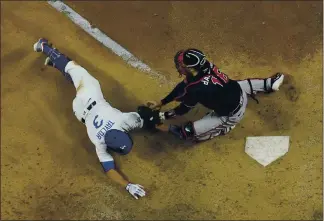  ?? DAVID J. PHILLIP — THE ASSOCIATED PRESS ?? The Dodgers’ Chris Taylor is tagged out at home by Braves catcher Travis d’Arnaud during the sixth inning in Game 7 of the NLCS on Sunday night in Arlington, Texas. The Dodgers won 4-3 to reach the World Series.