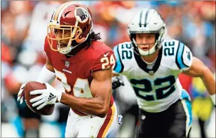  ?? / AP-Patrick Semansky ?? Redskins cornerback Josh Norman carries the ball after pulling in an intercepti­on as Panthers running back Christian McCaffrey pursues him during the first half of Sunday’s game in Landover, Md.