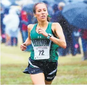  ?? PAUL W. GILLESPIE/CAPITAL GAZETTE ?? Arundel’s Niya Torres finishes first Tuesday afternoon in the varsity girls race at the Anne Arundel County cross country championsh­ip on a soggy course at South River High.