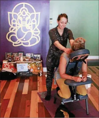  ?? TAWANA ROBERTS — THE NEWS-HERALD ?? Licensed massage therapist Bethany Soeder gives a chair massage at Branches of Wellness in Painesvill­e on March 8.