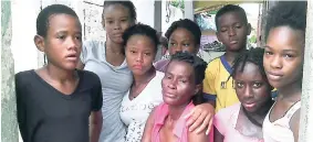  ?? PHOTO BY COREY ROBINSON ?? Sandra Brooks, mother of Nicholas Thomas (centre), sits with some of her children and friends at their home in Franklin Town, Kingston, yesterday.