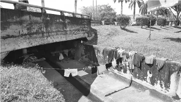  ??  ?? Clothes drying on the concrete wall of the storm drain indicating that someone is living in the storm drain.