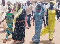  ?? | HARUNA UMAR/AP ?? Four female students who were abducted by gunmen and reunited with their families walk together in Chibok, Nigeria last month.