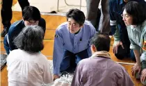  ??  ?? JAPAN’s Prime Minister Shinzo Abe (center) visits a shelter for people affected by the recent flooding in Mabi, Okayama prefecture in this July 11 photo.