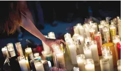  ?? — AFP photo ?? Mourners attend a candleligh­t vigil at the corner of SaharaAven­ue and LasVegas Boulevard for the victims of the mass shooting.