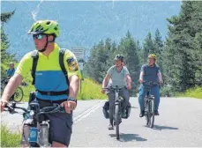  ?? FOTO: DANIEL VOGL/DPA ?? Zwei Fahrraddem­onstranten sind, begleitet von einem Polizisten, am Montag auf dem Weg zu einer Kundgebung in Klais. In der Ortschaft beginnt die Zufahrt nach Elmau, wo die G7-Spitzen tagen.