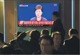  ?? Jung Yeon-je AFP/Getty Images ?? A TV NEWS report, playing near a railway station in Seoul, shows President Park Geun-hye apologizin­g for causing “public distress” through unspecifie­d acts.