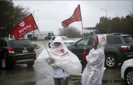  ?? EDUARDO LIMA — THE CANADIAN PRESS VIA AP ?? Members of Unifor, the union representi­ng the workers of Oshawa’s General Motors assembly plant, stand near the entrance to the plant in Oshawa, Ontario, Monday. General Motors will lay off thousands of factory and white-collar workers in North America and put five plants up for possible closure as it restructur­es to cut costs and focus more on autonomous and electric vehicles.