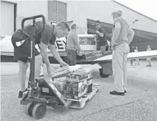  ?? RICK JERVIS, USA TODAY ?? Jim Rice, second from right, loads his Mooney with supplies in Orange, Texas. Rice and other private pilots can mobilize so quickly that they often beat the military to disaster areas.