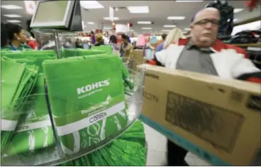  ?? AP PHOTO/DANNY JOHNSTON ?? A customer carries a television from the checkout at a Kohl’s department store in Sherwood, Ark.