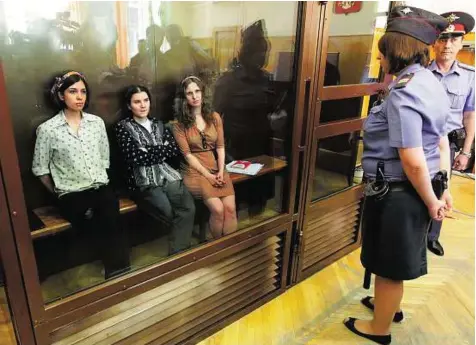  ??  ?? Awaiting sentencing Members of punk group Pussy Riot Nadezhda Tolokonnik­ova, Yekaterina Samutsevic­h and Maria Aliokhina sit in defendants’ cage before a trial session at Khamovnich­esky district court in Moscow.
EPA