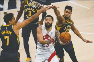  ?? AP PHOTO MICHAEL CONROY ?? Toronto Raptors guard Fred VanVleet (23) goes under Indiana Pacers guards Malcolm Brogdon (7) and Jeremy Lamb (26) to shoot during the second half of an NBA basketball game in Indianapol­is, Monday.