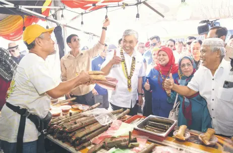  ?? — Photo by Chimon Upon ?? Ahmad Zahid (fourth right), accompanie­d by Kota Samarahan MP Datuk Rubiah Wang, on his le Mini Carnival in Kota Samarahan. , makes a stop at one of the stalls, at the Rural Entreprene­urs