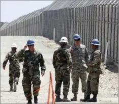  ?? PHOTO/ ?? In this June 21, 2006, file photo, members of the California National Guard work next to the U.S.-Mexico border fence on June 21, 2006, near the San Ysidro Port of Entry in San Diego. AP DENIS POROY