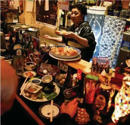  ?? REUTERS PIC ?? Tokyo pub owner Natsuko Takami fears losing money as she can’t afford new ventilatio­n, and could be fined if a customer smoked.