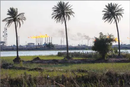  ?? ?? The Nihran Bin Omar oil field flare stacks burn north of Basra, Iraq, Wednesday, March 22, 2023. In the wake of the US invasion of Iraq in 2003 and toppling of Saddam Hussein, foreign investors flocked to the country’s abundant oil fields and contracts were doled out, filling Iraqi state coffers. (AP)