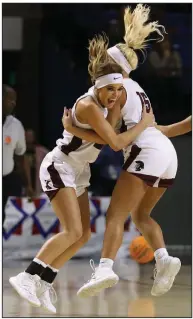  ?? available at arkansason­line.com/313girls1a. (Arkansas Democrat-Gazette/Thomas Metthe) More photos ?? Kirby’s Kaylee Dougan (left) celebrates with Adi Harmon after the Lady Trojans’ victory in the Class 1A girls state championsh­ip game Thursday at Bank OZK Arena in Hot Springs.