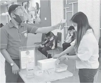  ?? PHOTOGRAPH BY DAVID JOHN CUBANGBANG FOR THE DAILY TRIBUNE @tribunephl_dvd ?? Hold it: First, a temperatur­e check; then alcohol to sanitize hands.