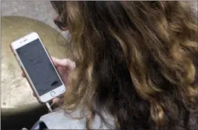  ?? MARY ALTAFFER - THE ASSOCIATED PRESS FILE PHOTO ?? A woman uses a ride-hailing app while waiting for a ride outside Grand Central Terminal in New York. Ride-hailing services are hoping customers will think along the same lines about their transporta­tion needs. Uber and Lyft recently launched subscripti­on plans promising savings for those trips to the gym, to work or around town.