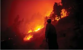  ??  ?? A firefighte­r checks on the evolution of the Castle Fire as it burns in the Sequoia national forest in September. Photograph: Étienne Laurent/EPA