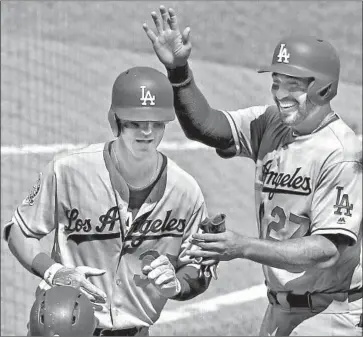  ?? Gene J. Puskar Associated Press ?? CODY BELLINGER IS GREETED by Matt Kemp after his two-run homer in the seventh inning gave the Dodgers a 6-3 lead. It was the third consecutiv­e game with a home run by Bellinger, who has been slumping.