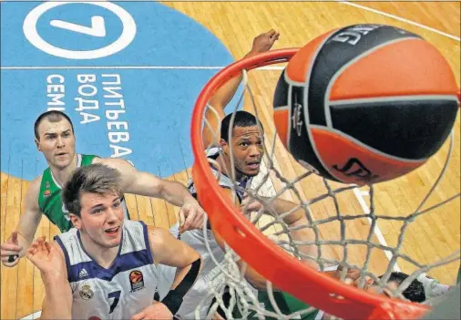  ??  ?? BUEN TRABAJO. Luka Doncic y Anthony Randolph pelean por la posición ante un posible rebote. El Madrid barrió en los rechaces al Unics.